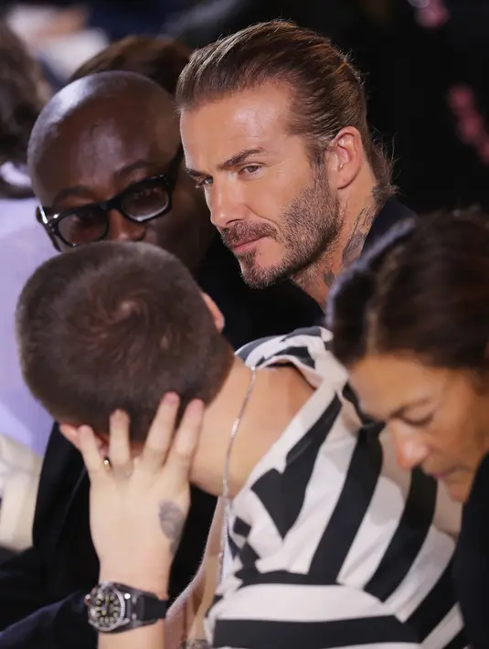 David Beckham dan putranya Brooklyn menyaksikan fashion show koleksi musim panas Victoria Beckham di New York Fashion Week, Minggu (10/9). David berada di barisan terdepan bersama sang putra  untuk menujukkan support mereka. (EDUARDO MUNOZ ALVAREZ / AFP)
