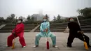 Sejumlah wanita mengunakan masker saat melakukan latihan bela diri pada pagi hari di Jinan, Provinsi Shandong, China, (10/11). Selama lima hari ini Cina mengalami kualitas udara yang menurun karena tercemar polusi. (REUTERS/Stringer)