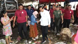 Presiden Joko Widodo atau Jokowi menyalami warga saat blusukan di Pasar Minggu, Jakarta, Jumat (22/2). Jokowi mengenakan kemeja putih lengan panjang, celana hitam, dan sepatu sneakers. (Liputan6.com/Angga Yuniar)