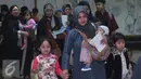 Seorang TKI bersama anaknya tiba di Bandara Soekarno Hatta,Tangerang, Rabu (11/11). Sebanyak 450 WNI overstayers dan TKI undocumented dari Jeddah, Arab Saudi dipulangkan pemerintah Indonesia untuk kembali ke kampung halaman. (Liputan6.com/Angga Yuniar)