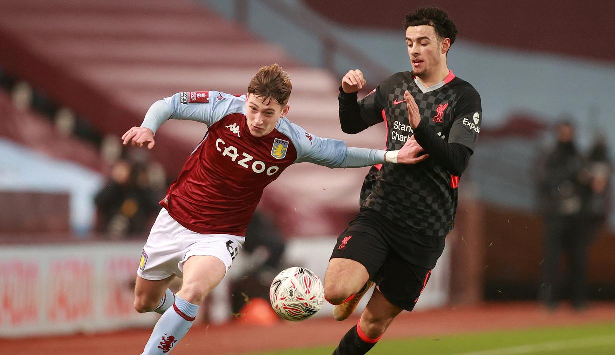 Striker Aston Villa, Louie Barry (kiri) berebut bola dengan gelandang Liverpool, Curtis Jones dalam laga babak ke-3 Piala FA 2020/21 di Villa Park, Birmingham, Jumat (8/1/2021). Aston Villa kalah 1-4 dari Liverpool. (AFP/Hannah McKay/Pool)