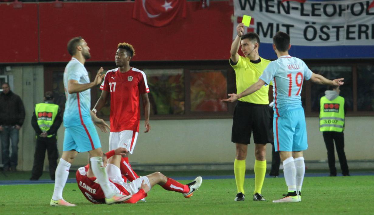 Wasit Pawel Gil asal Polandia memberikan kartu kuning kepada pemain Turki, Yunus Malli. (Bola.com/Reza Khomaini)