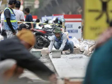 Pekerja menyelesaikan proyek revitalisasi trotoar di kawasan Kuningan, Jakarta, Senin (4/11/2019). Dinas Bina Marga DKI Jakarta menganggarkan biaya proyek revitalisasi trotoar sebesar Rp 1,1 triliun. (merdeka.com/Iqbal Nugroho)