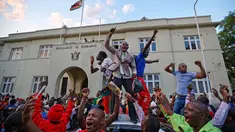 Warga Zimbabwe bergembira setelah kabar Presiden Robert Mugabe mengundurkan diri di luar gedung parlemen, pusat kota Harare, Selasa (21/11). Surat pengunduran diri Robert Mugabe itu mengakhiri masa pemerintahannya selama 37 tahun. (AP/Ben Curtis)