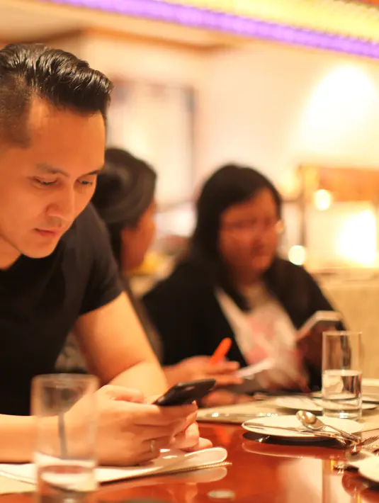 Terlihat asyik dengan telepn genggamnya di hari pertama tiba di Macau, Demian melakukan makan malam di restoran setempat. (Aldivano/Bintang.com)
