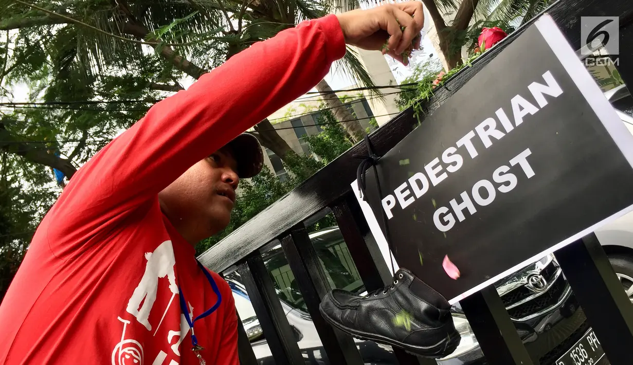 Aktivis Koalisi Pejalan Kaki menaburkan bunga di sekitar Halte Tugu Tani, Jakarta, Senin (22/1). Selain memperingati Hari Pedestrian, mereka juga memperingati enam tahun tragedi Tugu Tani. (Liputan6.com/Immanuel Antonius)
