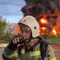 Foto dari Gubernur Sevastopol, Mikhail Razvozhaev, dari Telegram. Seorang pemadam kebakaran memantau kebakaran di tanki bahan bakar di Crimea pada Sabtu (29/4). Dok: Channel Telegram Gubernur Sevastopol Mikhail Razvozhaev via AP