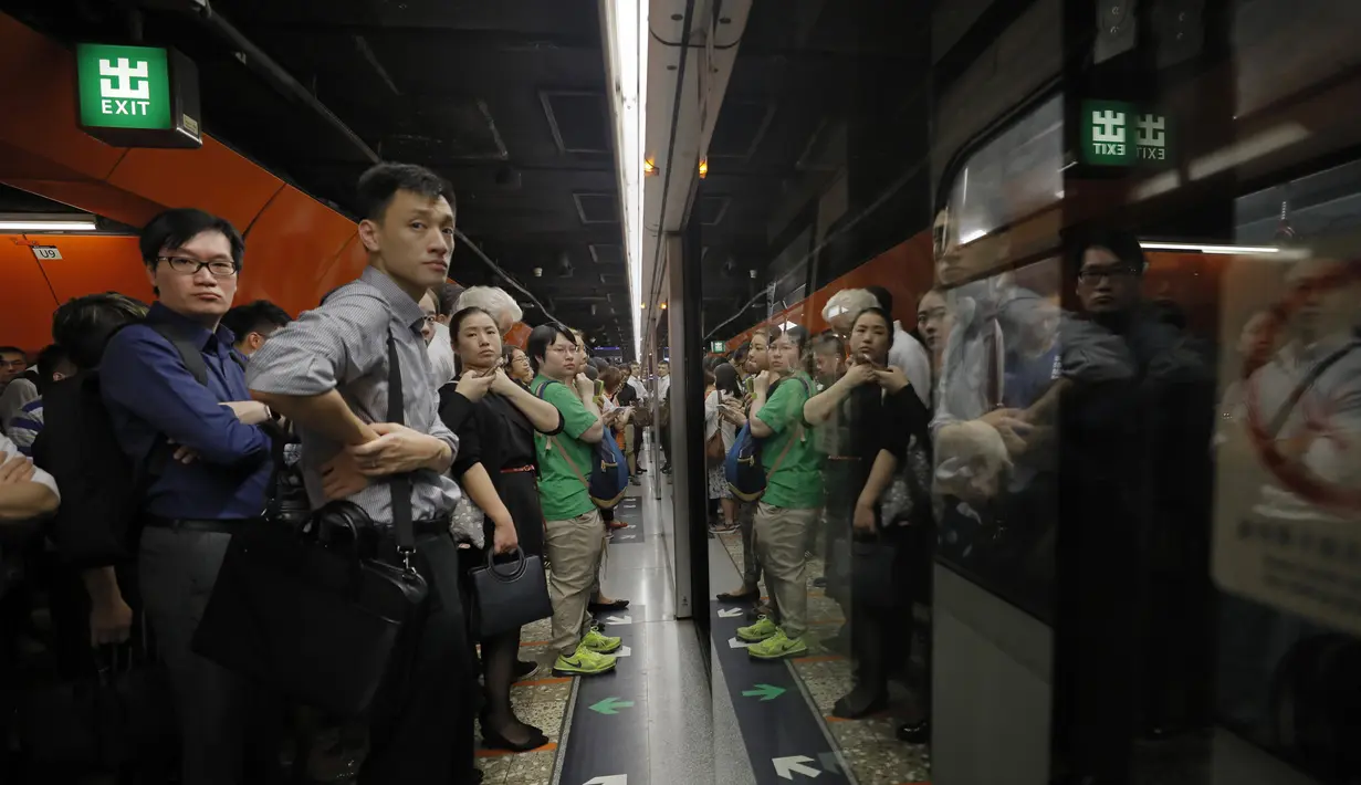 Penumpang mengantre di platform kereta bawah tanah di Hong Kong, Selasa (30/7/2019). Para pengunjuk rasa telah mengganggu layanan kereta bawah tanah pada pagi hari perjalanan dengan menghalangi pintu-pintu masuk kereta dan mencegah mereka meninggalkan stasiun. (AP Photo/Vincent Yu)