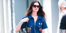 Anne Hathaway tampil mengenakan jumpsuit denim dengan aksen patch. Ia membawa Tas Valentino Garavani Panthea hitam yang  diperkenalkan dalam koleksi Fall Winter 2025/2026 bertajuk Le Méta-Théâtre Des Intimités oleh Creative Director Valentino, Alessandro Michele. [Dok. Valentino]