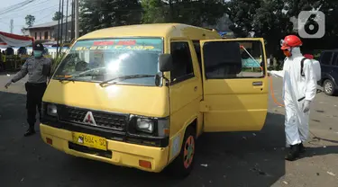 Petugas menyemprot mobil yang ingin menuju wilayah Sukabumi dengan cairan disinfektan di Terminal Cicurug, Sukabumi, Jawa Barat, Minggu (12/4/2020). Proses sterilisasi ini dilakukan untuk mencegah penyebaran virus corona COVID-19. (merdeka.com/Arie Basuki)