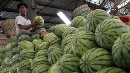 Pekerja mengangkut buah segar di Pasar Induk Kramat Jati, Jakarta, Selasa (9/6/2015). Jelang Ramadan, permintaan buah segar dari Dalam Kota meningkat hingga 100 persen. Buah Blewah dijual  Rp6.000/kg dan Semangka  Rp7.000/kg. (Liputan6.com/Helmi Afandi)