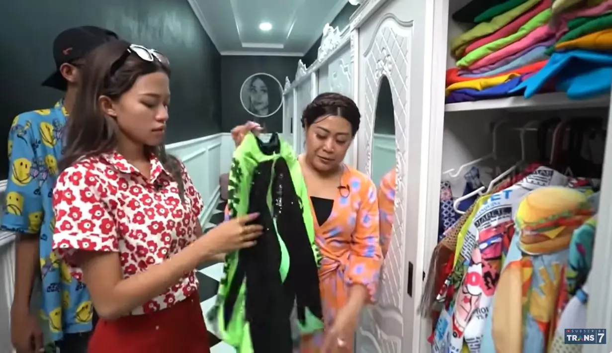 Berikut merupakan ruangan yang biasa digunakan untuk menyimpan pakaian hingga sepatu. Tampak ada beberapa lemari yang pakaiannya sudah dikelompokkan sesuai keperluan. Sedangkan lemari yang ditunjukkan ini merupakan koleksi pakaiannya saat jadi biduan. [Youtube/TRANS7 OFFICIAL]