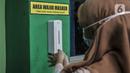 Guru menggunakan hand sanitizer sebelum memasuki kelas saat Simulasi Persiapan Kelas Hybrid dalam Pembelajaran Jarak Jauh di SMPN 255, Jakarta, Selasa (30/3/2021). Kelas Hybrid merupakan model sekolah tatap muka secara rotasi dengan jumlah kehadiran siswa 50 persen. (merdeka.com/Iqbal S Nugroho)