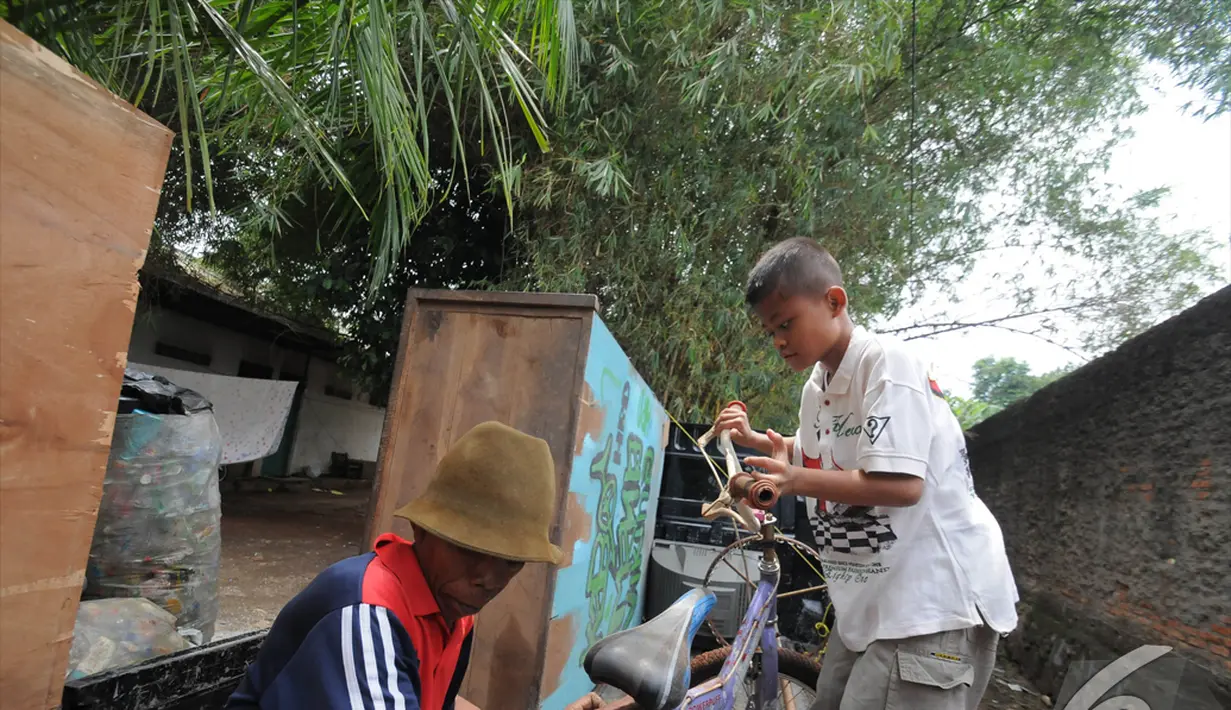 Sony Wakwaw membawa sepeda kesayangannya saat pindah rumah di kawasan Cibubur, Jakarta Timur. Foto diambil pada Kamis (4/12/2014). (Liputan6.com/Herman Zakharia)