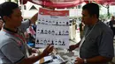 Petugas menjelaskan surat suara saat simulasi pencoblosan dan penghitungan di TPS pada Pemilihan umum 2019 di Kecamatan Tanah Abang, Jakarta, Selasa (9/4). Simulasi ini untuk memahami alur dan aturan Pemilu pada 17 April 2019. (merdeka.com/Imam Buhori)