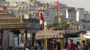 Orang-orang duduk di distrik Eminonu dengan latar belakang Menara Galata, di Istanbul, Selasa (27/7/2021). Turki telah mencatat lebih dari 15.000 kasus virus corona baru, karena jumlah infeksi yang terus meningkat. (AP Photo/Mucahid Yapici)