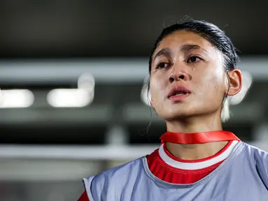 Pemain Timnas Indonesia Putri, Zahra Muzdalifah meneteskan air mata saat menyanyikan lagu kebangsaan Indonesia Raya sebelum laga persahabatan melawan Singapura di Stadion Madya, Senayan Jakarta, Selasa (28/05/2024). (Bola.com/Bagaskara Lazuardi)