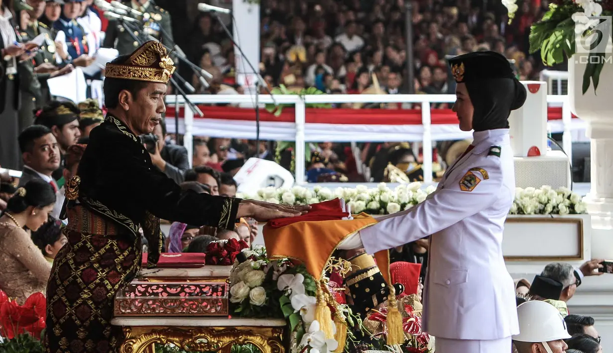 Presiden Joko Widodo menyerahkan duplikat bendera pusaka kepada Paskibraka Salma El Mutafaqqiha dalam Upacara Peringatan Detik-Detik Proklamasi Kemerdekaan Indonesia ke-74 Tahun 2019 di Istana Merdeka, Jakarta, Sabtu (17/8/2019).  (Liputan6.com/HO/Kentung)
