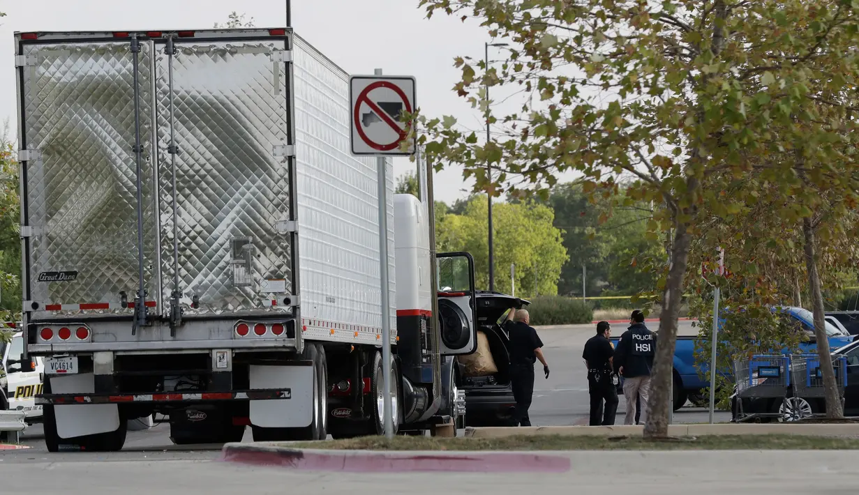 Polisi San Antonio selidiki sebuah truk yang berada di lapangan parkir supermarket, Texas, Minggu (23/7).  Total sebanyak 39 orang diperkirakan merupakan korban perdagangan manusia ditemukan berdesakan di dalam truk yang pengap itu. (AP Photo/Eric Gay)