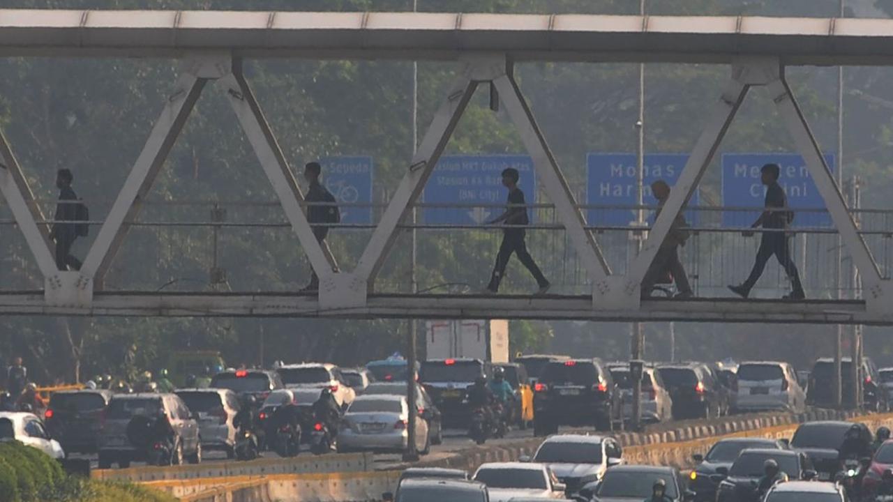 Sejumlah pekerja berjalan melewati Jembatan Penyeberangan Orang (JPO)&nbsp;di kawasan Jalan Sudirman, Jakarta, Selasa (27/8/2024). Badai pemutusan hubungan kerja (PHK) menghantam Indonesia. Berdasarkan data Kementerian Tenaga Kerja (Kemnaker),&nbsp;terdap