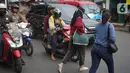 Pejalan kaki menyeberangi jalan di depan Stasiun Lenteng Agung, Jakarta, Senin (4/11/2019). Meski telah tersedia JPO, sebagian pejalan kaki lebih memilih untuk menyeberang sembarangan sehingga mengganggu arus lalu lintas serta berpotensi menimbulkan kecelakaan. (Liputan6.com/Immanuel Antonius)