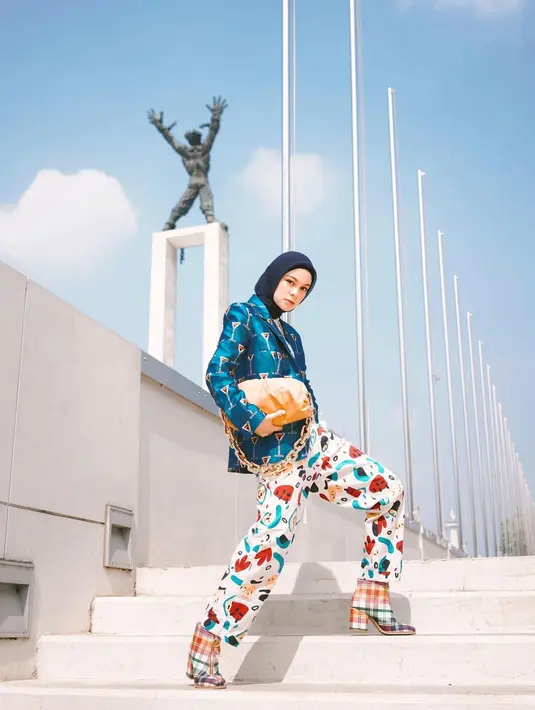 Selalu jadi pilihan, berpose di atas tangga membuat seseorang jadi terlihat lebih tinggi apabila angle foto diambil dari bawah. Selain itu, pose di atas tangga ini juga terlihat elegan karena memperlihatkan desain dari tangga yang dijadikan sebagai tempat pemotretan. Kenakan outfit motif mulai dari blazer, celana hingga heel boots, Tantri Namirah tampil bak ABG. (Liputan6.com/IG/@tantrinamirah)