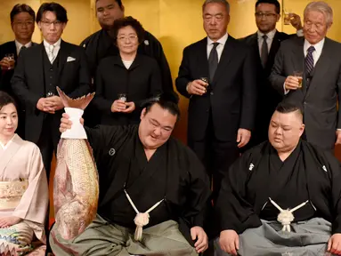Pegulat sumo Jepang, Kisenosato foto bersama saat mendapat hidangan ikan red sea bream merayakan kemenangannya dalam upacara yang berlangsung di Tokyo, Jepang, Rabu (25/1). (AFP Photo/Toru Yamanaka) 