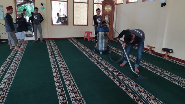 Menggunakan vakum cleaner, beberapa anggota komunitas nampak tengah membersihkan karpet masjid Agung Sirotul Jannah, Cikelet, Garut