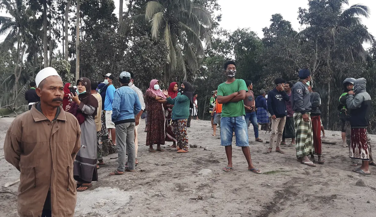 Penduduk desa memeriksa di daerah yang terkena dampak letusan Gunung Semeru di Lumajang, Jawa Timur, Indonesia, Minggu (5/12/2021). Gunung Semeru memuntahkan kolom tebal abu, gas yang membakar dan lava menuruni lerengnya dalam letusan tiba-tiba yang dipicu oleh hujan lebat. (AP Photo/Rokhmad)