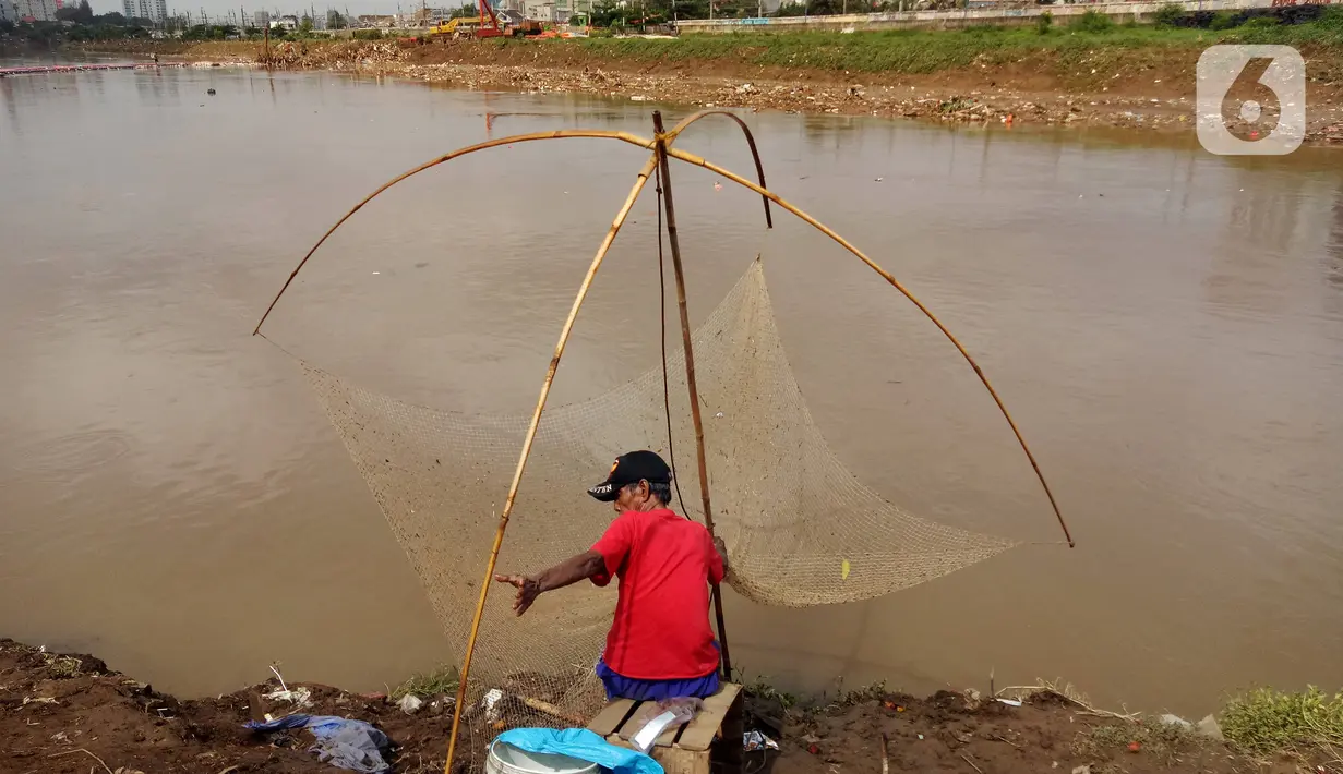 Warga mencari ikan dengan menggunakan jala di Banjir Kanal Barat, Tanah abang, Jakarta, Sabtu (4/1/2020). Debit air yang mulai surut di aliran tersebut dimanfaatkan warga untuk mencari ikan. (Liputan6.com/Angga Yuniar)