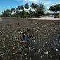 Warga Maratua yang didominasi anak-anak mencari sesuatu di tengah lautan sampah di Pulau Maratua.