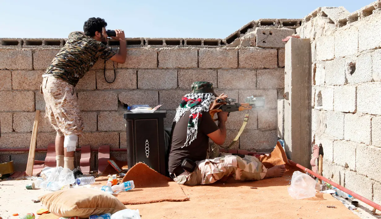 Para pasukan militer pemerintah Libya melepaskan tembakan dari lubang beton saat melakukan serangan ke pada para pejuang ISIS dari atap atap rumah di daerah Zaafran, di Sirte, Libya, 30 Juni 2016. (REUTERS/Ismail Zitouni)