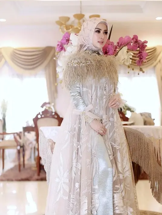 Syahrini berpose mengenakan gamis mewah berwarna krem dengan hiasan rumbai-rumbai di pundak. (Liputan6.com/Instagram/@princessyahrini)