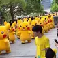 Para pejalan kaki teralihkan perhatiannya dengan barisan Pikachu, si pokemon kuning lucu.