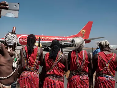 Seorang penari berselfie saat kedatangan pesawat khusus yang membawa trofi Piala Dunia FIFA selama Tur Dunia di bandara Internasional Jomo Kenyatta di Nairobi, Kenya (26/2). Turnamen Piala Dunia akan dimulai Juni di Rusia. (AFP Photo/Yasuyoshi Chiba)