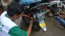 Motir memperbaiki sepeda motor korban banjir pada layanan bengkel gratis Badan Amil Zakat Nasional (BAZNAS) di Kampung Pulo, Jakarta, Sabtu (4/1/2020). Layanan bengkel gratis ini banyak dimanfaatkan korban banjir untuk memperbaiki sepeda motornya yang sempat terendam. (merdeka.com/Imam Buhori)