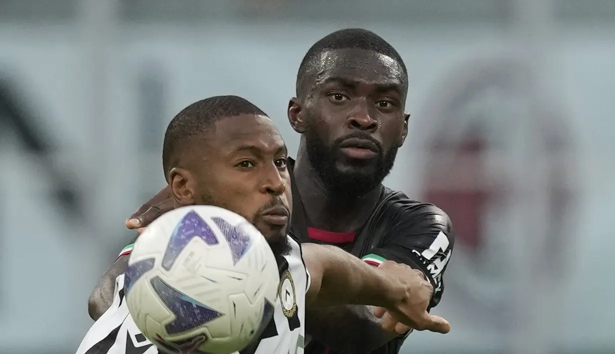 Bek AC Milan, Fikayo Tomori berebut bola dengan penyerang Udinese, Beto pada pertandingan Liga Serie A Italia di stadion San Siro, di Milan, Italia, Sabtu (13/8/2022). AC Milan menang atas Udinese 4-2. (AP Photo/Antonio Calanni)