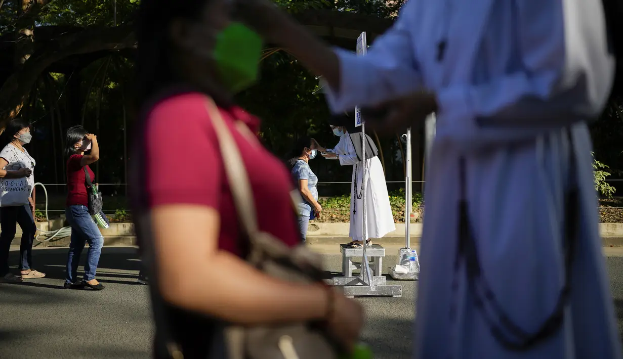 Biarawati Katolik menandai dahi umat dengan salib abu di Gereja Redemptorist selama Rabu Abu di Manila, Filipina (2/3/2022). Jutaan orang Filipina beramai-ramai ke gereja dan dahi mereka ditandai dengan salib abu untuk memperingati Rabu Abu. (AP Photo/Aaron Favila)