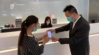 Seorang pegawai sedang membantu nasabah untuk melakukan aktivasi BNI Mobile Banking di BNI Hong Kong pada Selasa (24/3/2020).