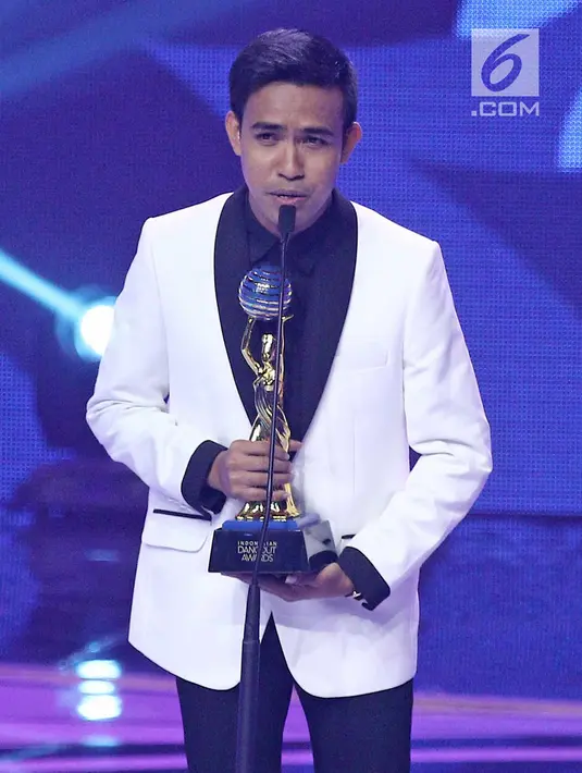 Penyanyi dangdut Fildan DA menerima piala untuk kategori penyanyi dangdut pendatang baru pria terbaik dalam ajang Indonesian Dangdut Awards 2017 di Studio 6 EMTEK CITY, Jakarta, Jumat (13/10). (Liputan6.com/Herman Zakharia)