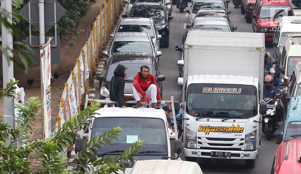 Pelajar menumpang truk terbuka yang melintas di kawasan Lenteng Agung, Jakarta, Senin (8/4). Perilaku buruk tersebut membahayakan keselamatan diri mereka dan pengguna jalan lain. (Liputan6.com/Immanuel Antonius)