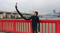 Mansun menciptkan "lengan selfie," yakni tongkat super panjang yang dilengkapi tangan palsu untuk melakukan selfie.