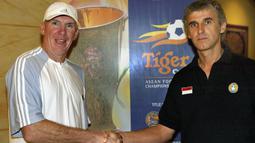 Peter Withe (kiri). Pelatih asal Inggris berusia 71 tahun yang sejak Mei 2018 resmi menjadi pemilik klub Deffo FC yang berlaga di kasta ketiga Liga Thailand ini total mengoleksi 2 gelar Piala AFF sepanjang sejarah. Kedua trofi tersebut diraihnya bersama Timnas Thailand pada Piala AFF edisi 2000 dan 2002. Peter Withe sendiri secara keseluruhan membesut Timnas Thailand selama 5 tahun mulai Juli 1998 hingga Desember 2003. Selain 2 gelar Piala AFF, ia juga berjasa membawa Timnas Thailand merebut medali emas pada ajang SEA Games 1999. (AFP/World Sport Group/Stanley Chou)