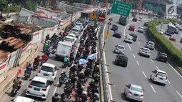 Konvoi buruh menggunakan sepeda motor melintas di Jalan Gatot Soebroto, Jakarta, Selasa (1/5). Ribuan buruh dari berbagai elemen memperingati perayaan Hari Buruh untuk menyampaikan aspirasi di sejumlah titik di Ibukota. (Liputan6.com/Immanuel Antonius)