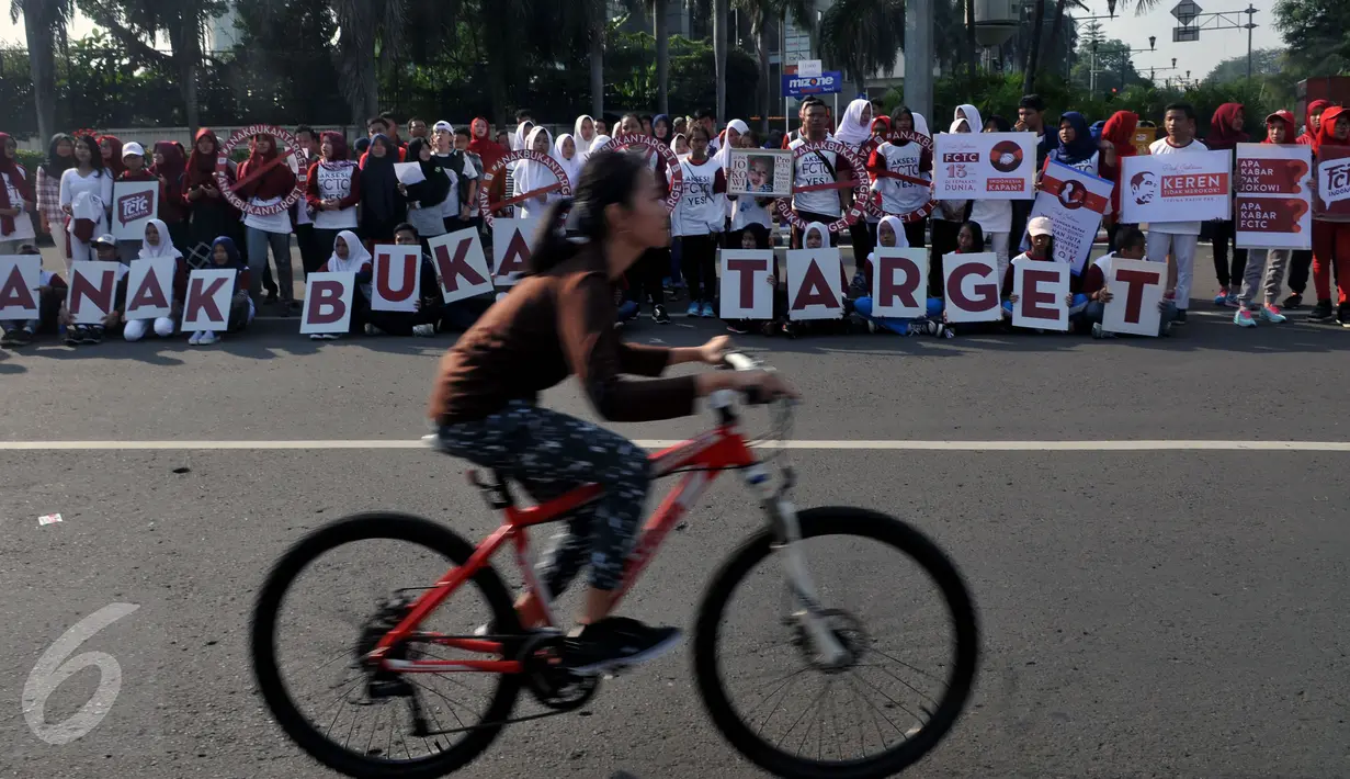 Massa dari Lentera Anak Indonesia berfoto bersama saat aksi solidaritas di Bundaran HI Jakarta, Minggu (24/7). Memperingati Hari Anak, mereka meminta Presiden Jokowi melindungi anak-anak Indonesia dari dampak konsumsi rokok. (Liputan6.com/Johan Tallo)