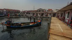 Nelayan membawa kerang hijau usai melaut ke rumahnya yang sudah direnovasi menjadi rumah apung  di Kampung Nelayan Muara Angke, Jakarta Utara, Rabu (14/8/2024). (merdeka.com/Arie Basuki)