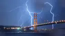 Kilatan petir terlihat di atas jembatan Golden Gate di San Francisco, California, AS (11/9). Petir merupakan Gejala alam yang biasanya muncul pada musim hujan di saat langit memunculkan kilatan cahaya sesaat yang menyilaukan. (AFP Photo/Josh Edelson)