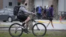 Seorang siswa yang mengenakan masker mengendarai sepeda ke sekolah di Vancouver, British Columbia, Kanada, 21 September 2020. Paparan COVID-19 telah dilaporkan di sedikitnya 20 sekolah di British Columbia sejak para siswa kembali belajar di sekolah dua pekan lalu. (Xinhua/Liang Sen)
