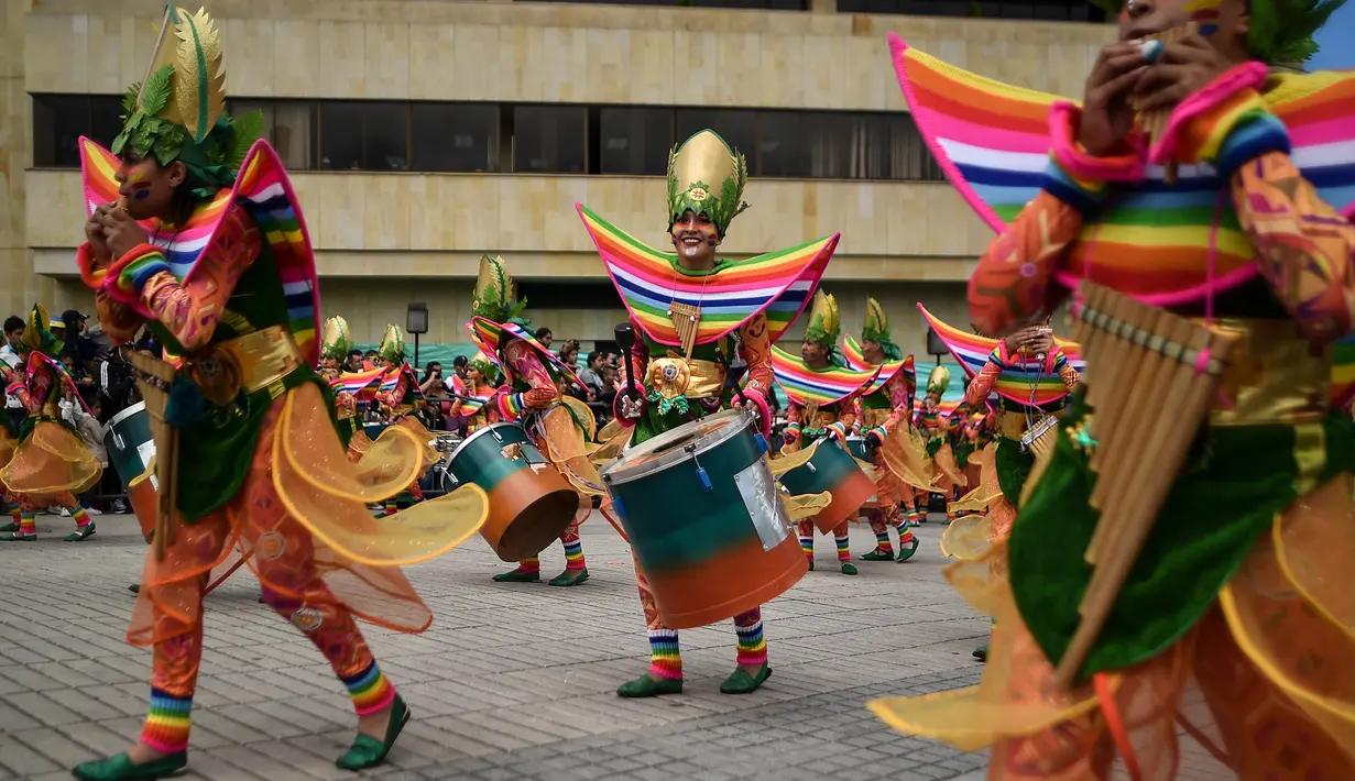 Peserta mengenakan kostum dan riasan memainkan alat musik saat parade Canto a la Tierra di Pasto, Kolombia (3/1). Lebih dari 10.000 orang yang terdiri dari seniman dan pengrajin memeriahkan karnaval ini. (AFP Photo/Luis Robayo)