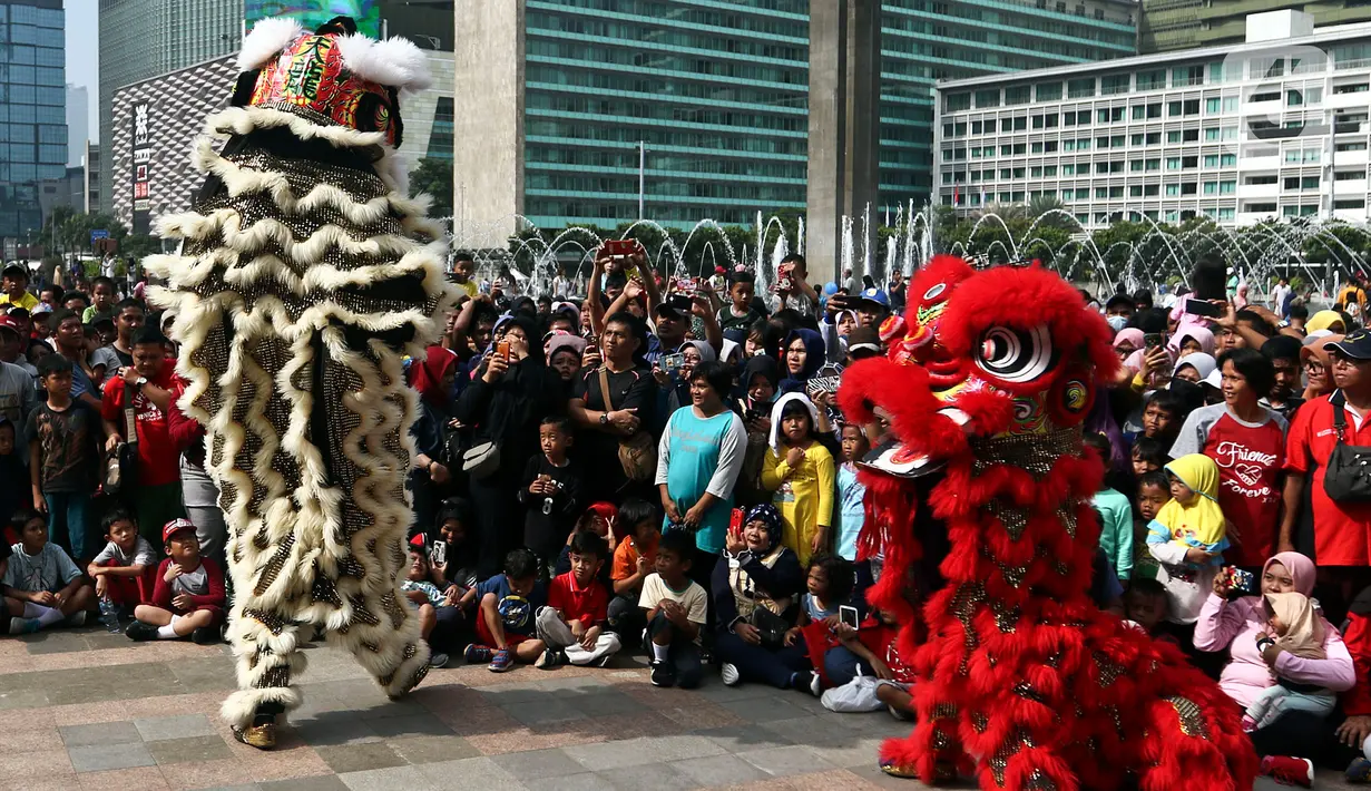 Warga menyaksikan pertunjukkan barongsai saat ajang car free day (CFD) di kawasan Bundaran HI Jakarta, Minggu (26/1/2020). Barongsai tersebut sengaja dihadirkan dalam rangka perayaan Imlek 2020 untuk menghibur para warga yang tengah mengikuti CFD. (Liputan6.com/Johan Tallo)
